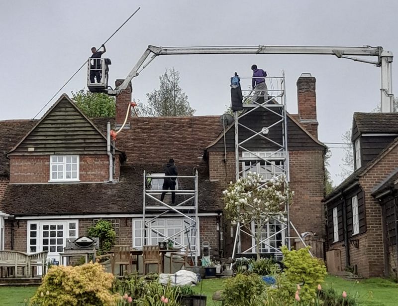 The Moss Cleaners using cherry picker and scaffolding to clean roof safely and professionally in Virginia Water, Surrey